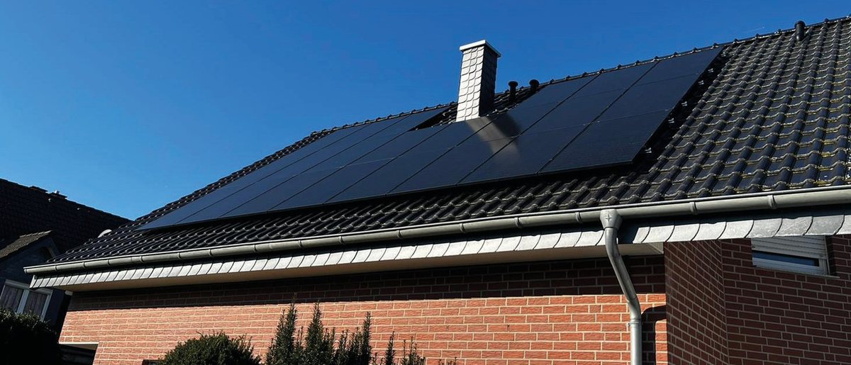 Satteldach eines Wohnhauses, vollflächig mit schwarzen Photovoltaikmodulen belegt